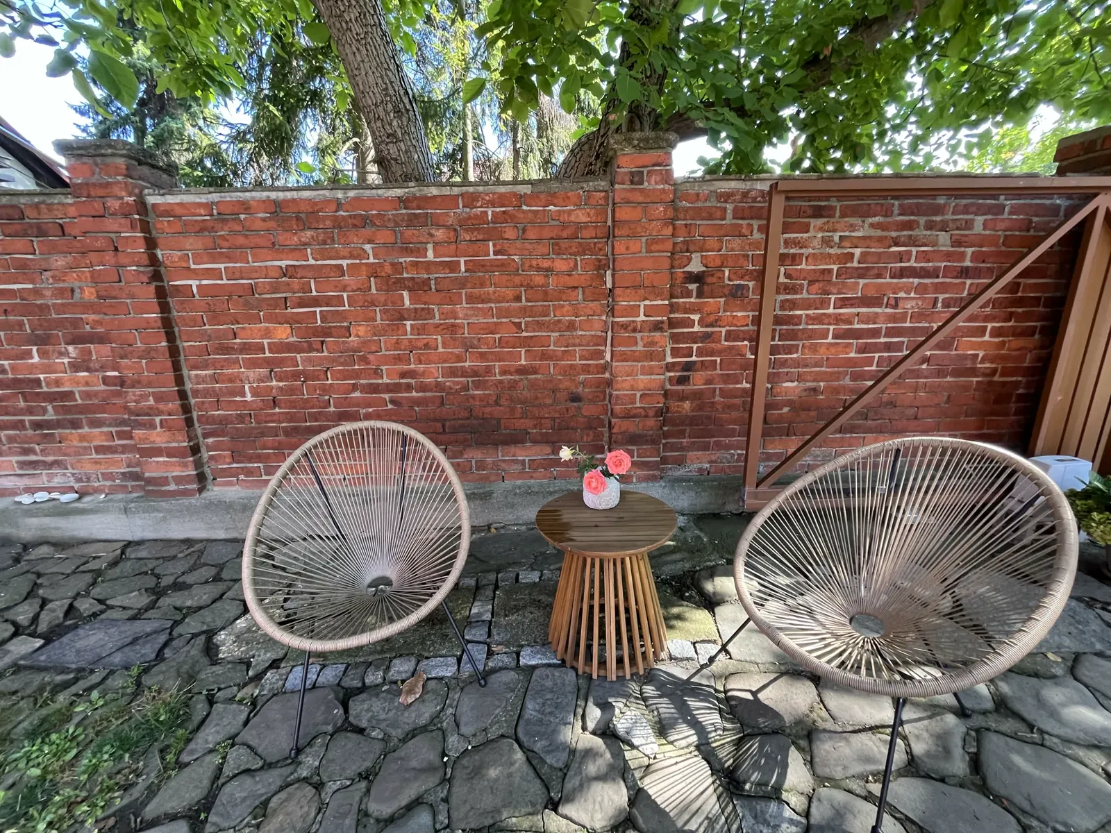 Posezení na dvoře u cihlové zdi pod stromy