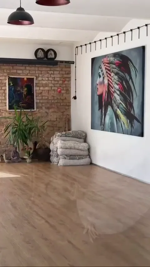 Sál s obrazem indiánky na zdi a jógovými polštáři
